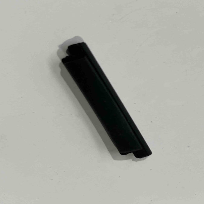 A black cylindrical object, resembling a pen cap or small tube, rests on a white surface. It could easily be mistaken for the ES600P protective cover by Go2place-okai-parts, part number 2020200130.
