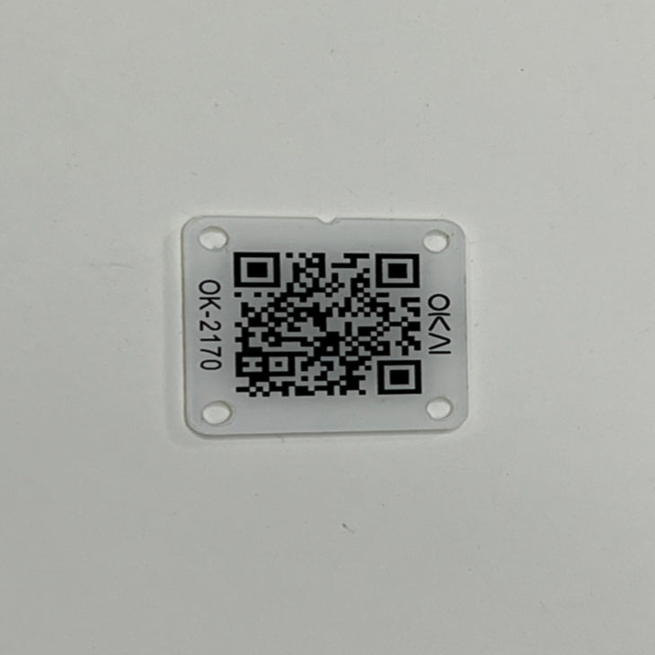 A sleek, square ES600P QR code plate by Go2place-okai-parts is white with a black QR code centrally positioned. Featuring four corner holes, it has OK-N and OK-2710 printed vertically on its minimalist backdrop. Part number 3040200102 highlights this elegant design.