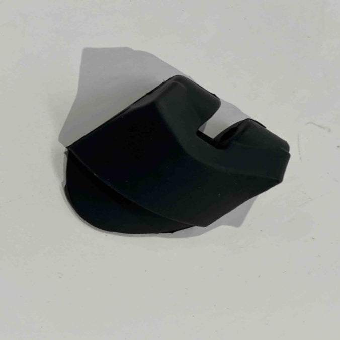 A black, angular ES600P headlight spacer from Go2place-okai-parts rests against a white background. Its shadow stretches to the left, enhancing its sculptural form and inviting inspection to reveal its enigmatic design and purpose.